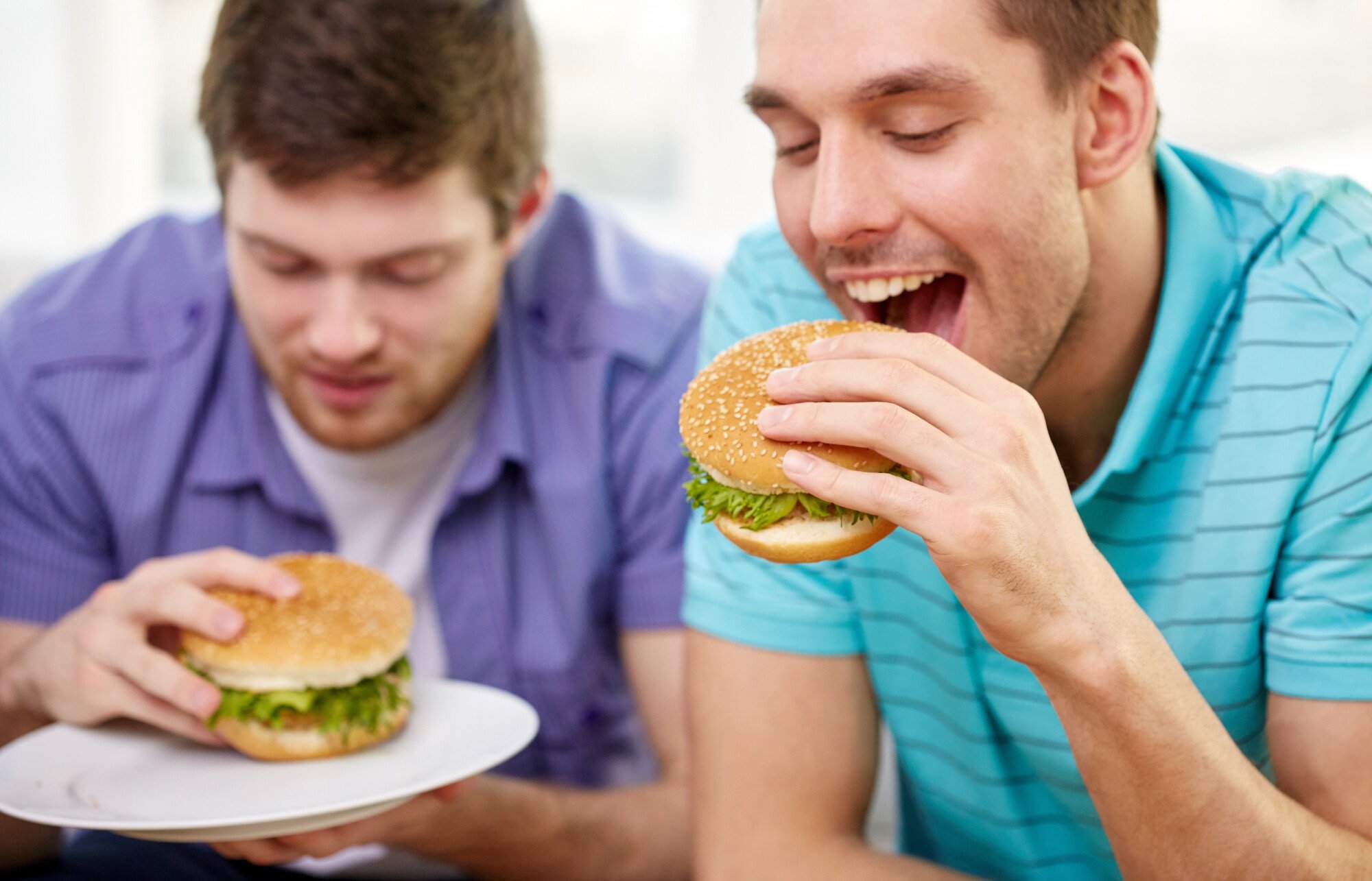 Two people eating burgers